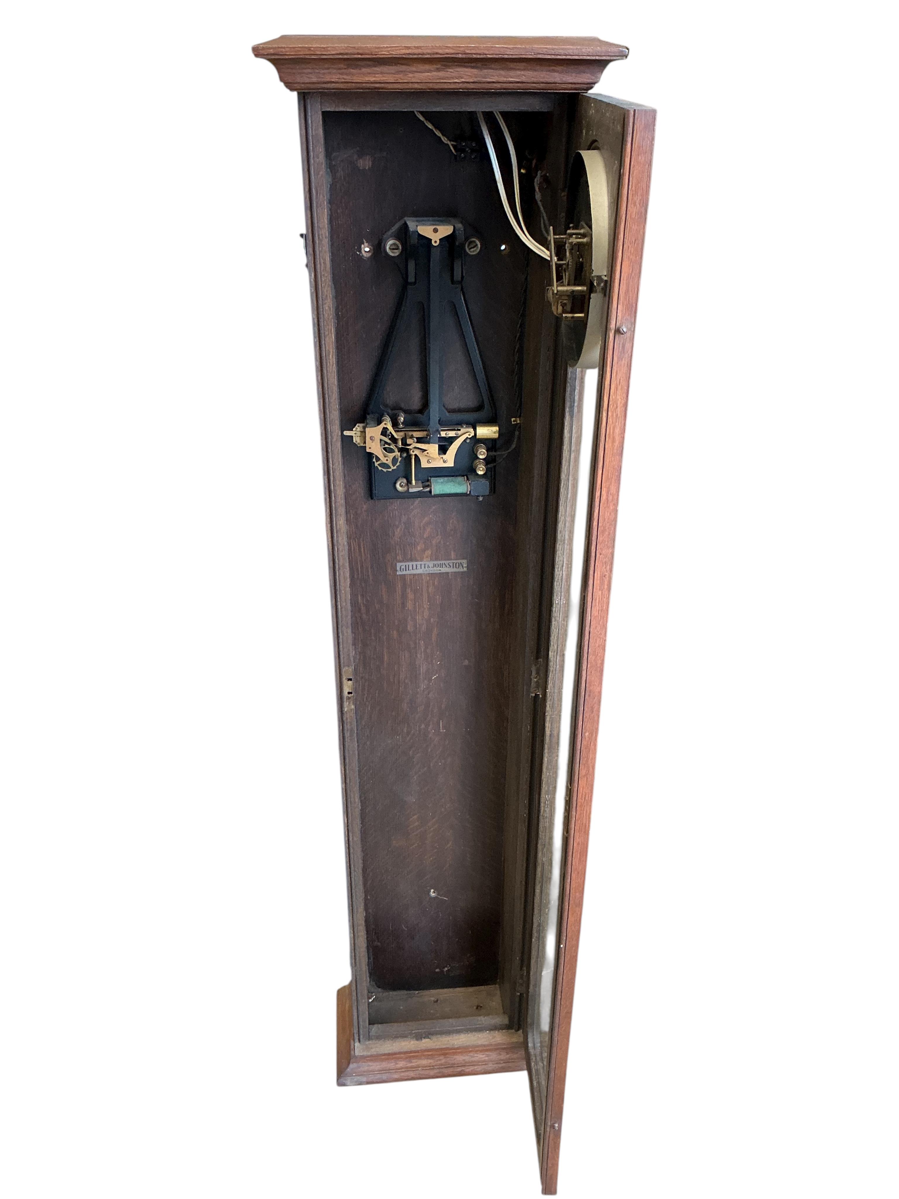 A Gillett & Johnston oak cased electric Master wall clock, with pendulum, height 139cm